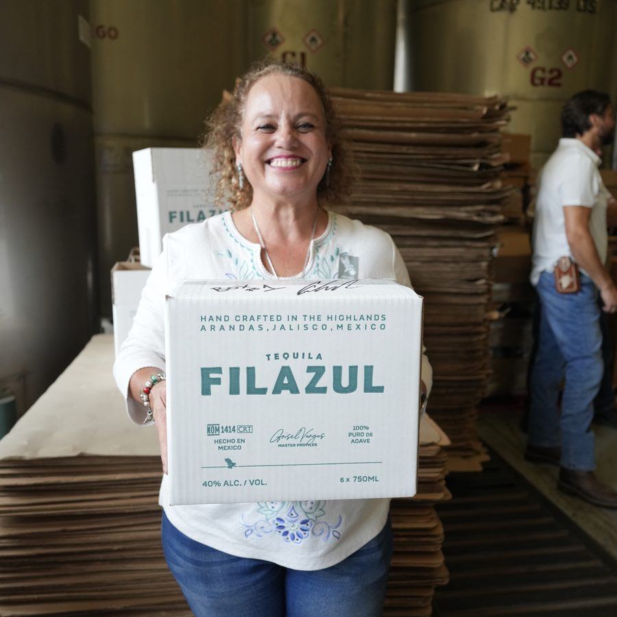 Grisel Vargas, Master Profiler, holding a case of FILAZUL at the distillery